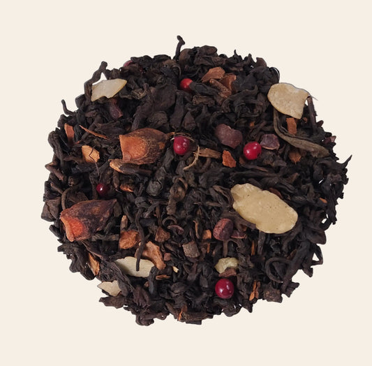 Mélange de thé Pu Erh en vrac avec bâtons de cannelle, éclats de fèves de cacao et amandes effilées pour une infusion de Noël gourmande.