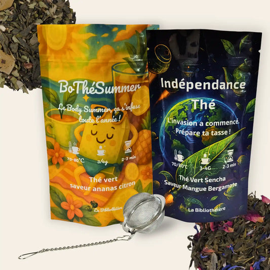 Bundle de thé comprenant deux sachets de thé vert en vrac de La Bibliothéière : Indépendance (saveur mangue bergamote) et BoThéSummer (saveur ananas citron), accompagnés d'une boule à thé en inox et de feuilles de thé séchées.