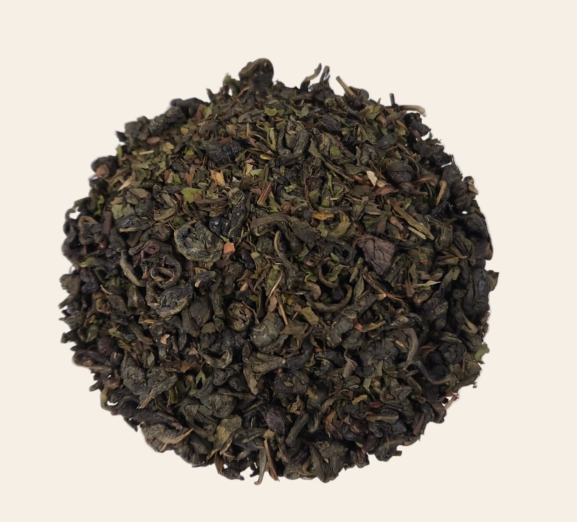 Feuilles de thé vert Gunpowder roulées en billes avec feuilles de menthe poivrée séchées pour une infusion intense et rafraîchissante.