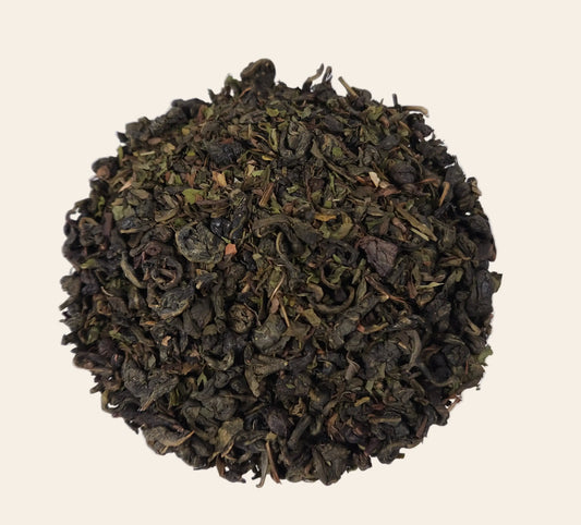 Feuilles de thé vert Gunpowder roulées en billes avec feuilles de menthe poivrée séchées pour une infusion intense et rafraîchissante.