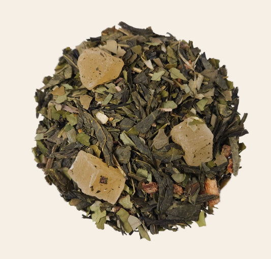 Gros plan sur le mélange de thé vert en vrac avec de larges morceaux d'ananas confits et zestes de citron.