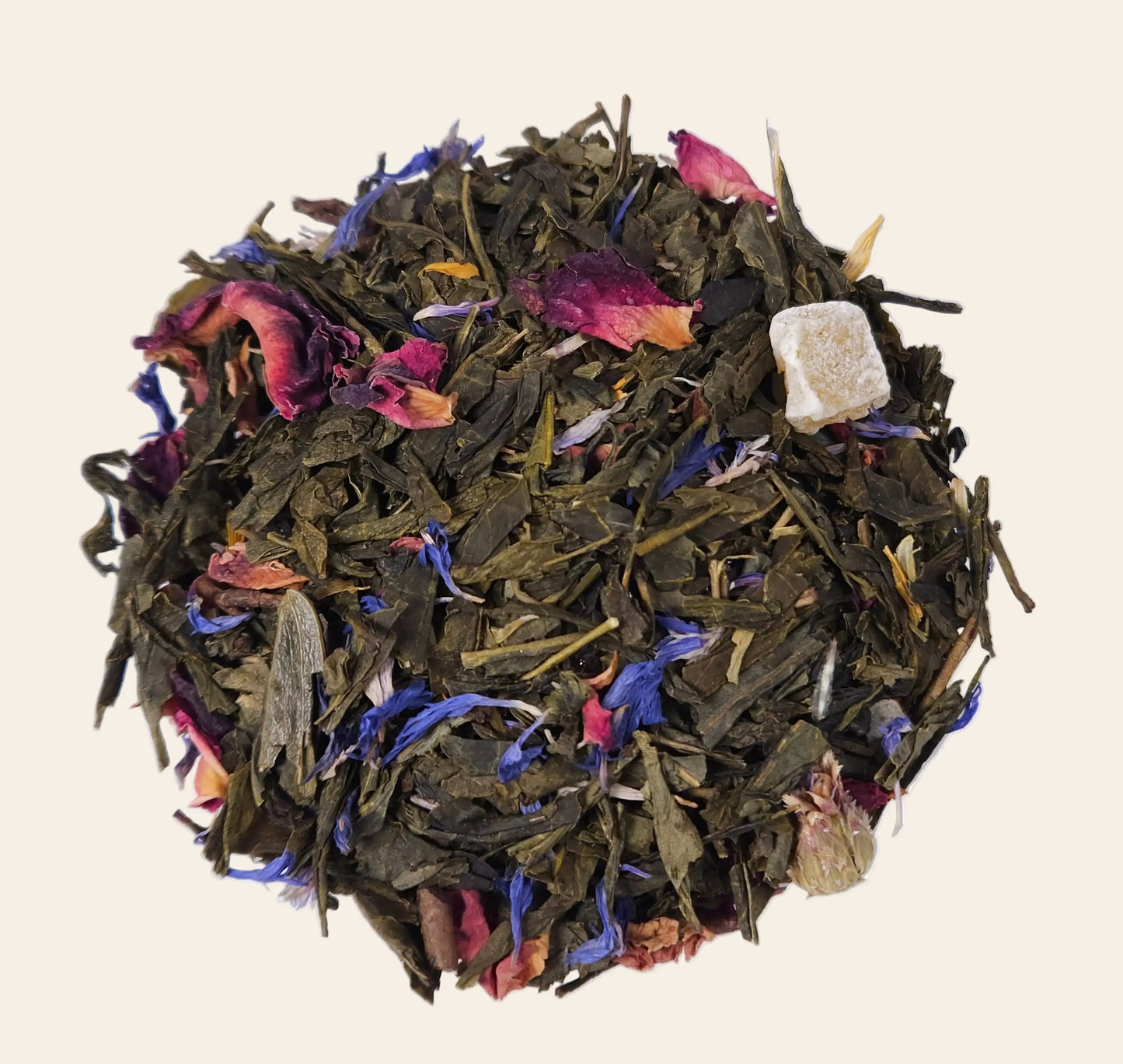 Mélange de thé vert en vrac avec morceaux de mangue, bergamote et pétales de fleurs bleues séchées pour une infusion parfumée.