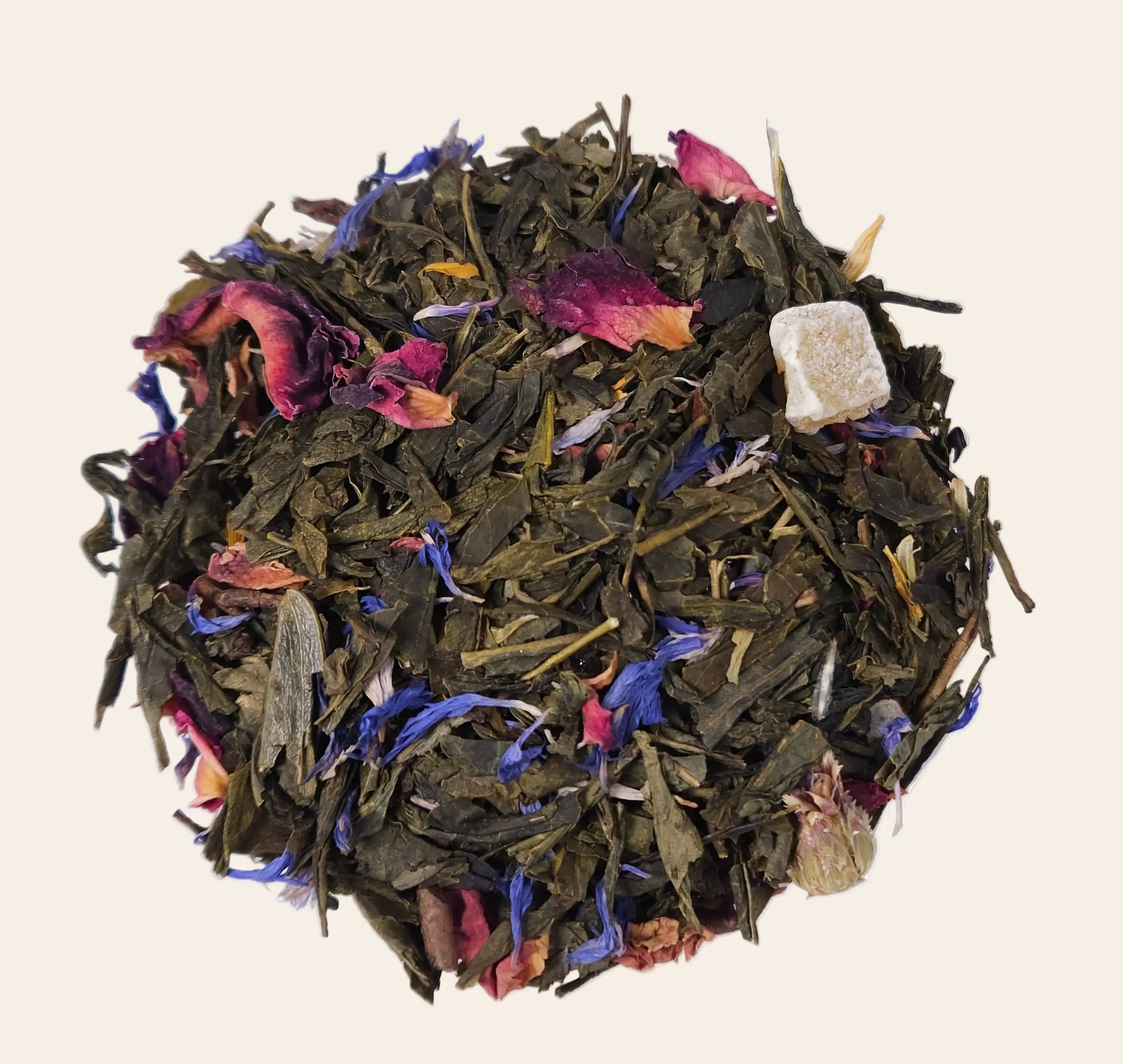 Mélange de thé vert en vrac avec morceaux de mangue, bergamote et pétales de fleurs bleues séchées pour une infusion parfumée.